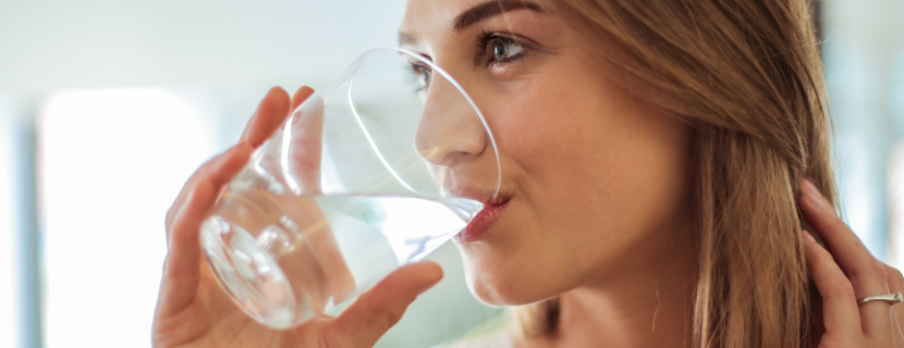 close up of a woman sipping a glass of water