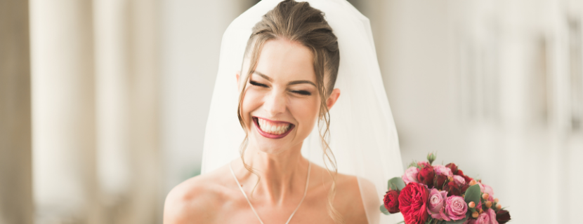 woman smiling in wedding dress holding bouquet 